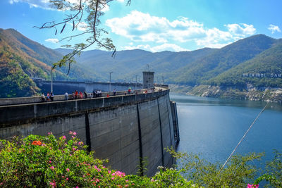 Scenic view of lake by mountains against sky