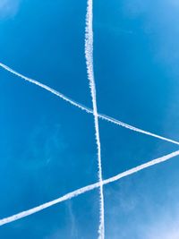 Low angle view of vapor trail against blue sky