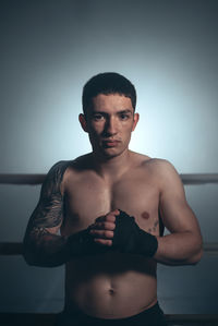 Portrait of shirtless man standing against white background