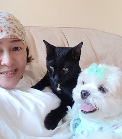 Portrait of woman with cat on bed