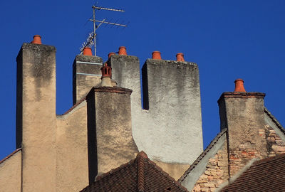 Low angle view of old building with chimneys against sky