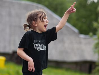 Girl pointing while standing outdoors