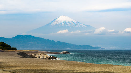 Scenic view of sea and mountains against sky