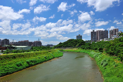 River amidst city against sky