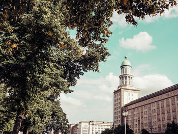 Low angle view of trees and buildings against sky