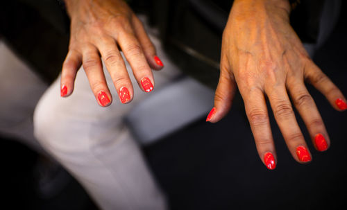 High angle view of woman showing painted fingernails