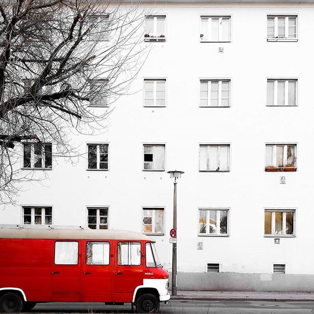 transportation, land vehicle, building exterior, mode of transport, architecture, car, built structure, street, city, parking, red, stationary, parked, window, bicycle, tree, bare tree, road, building, residential building