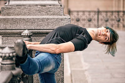 Midsection of man relaxing on street in city