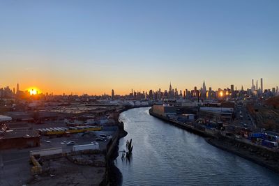 Panoramic view of river and buildings against sky during sunset