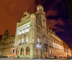Low angle view of illuminated building against sky at night
