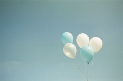 Low angle view of balloons flying against sky