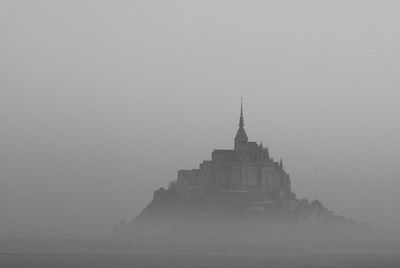 Castle in the fog against the clear sky