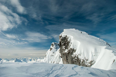 Scenic view of snowcapped mountain against cloudy sky