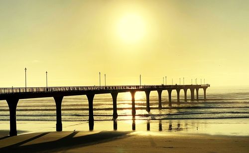 Pier over sea against sky during sunset