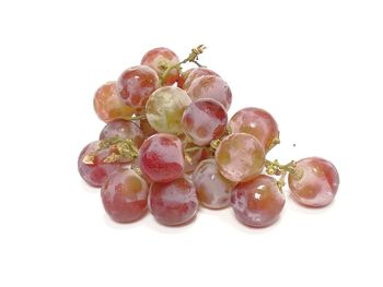 Close-up of grapes over white background