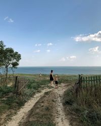 People walking on beach against sky