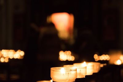 Close-up of illuminated candles burning at night