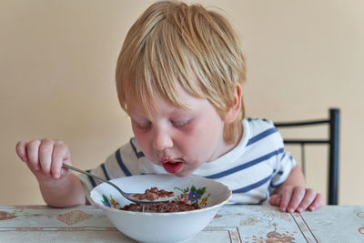 Close-up of boy eating food at home