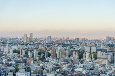 Aerial view of buildings in city against romantic sky