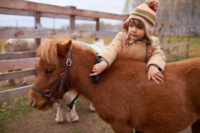 Little child spending time on horse farm