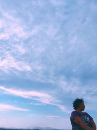 Low angle view of woman standing against sky