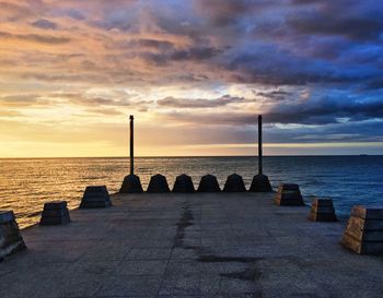 Scenic view of sea by pier against sky during sunset