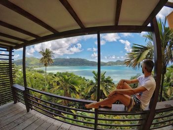 Woman sitting on railing looking at view