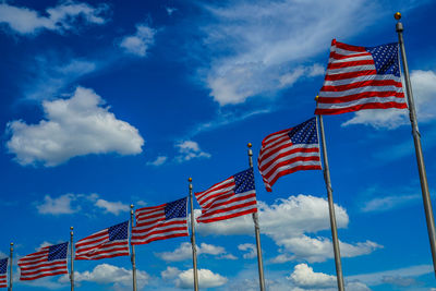 Low angle view of american flags against sky