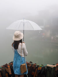 Rear view of woman holding umbrella