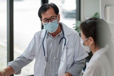 Side view of female doctor examining patient at home