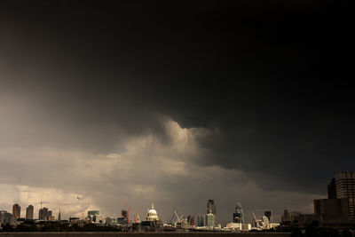 Buildings against storm clouds in city