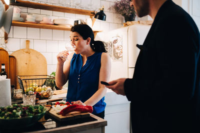 Woman holding food while standing on table