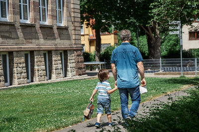 Dad leads the child to school or kindergarten. beginning of training sessions after summer holidays.