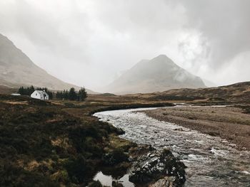 Scenic view of river and mountains against sky