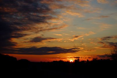 Scenic view of dramatic sky over silhouette landscape