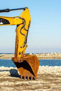 View of yellow machine on beach against clear sky