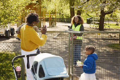 Mother with two daughters in park talking to volunteer