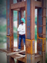 Man standing by metal structure