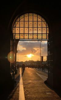 Illuminated street against sky during sunset