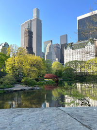 Buildings by river against sky