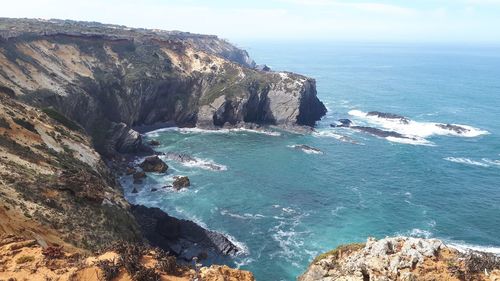 Scenic view of rocks in sea against sky