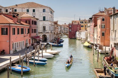 Boats in canal amidst buildings in city