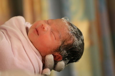 Cropped hand of doctor holding newborn baby