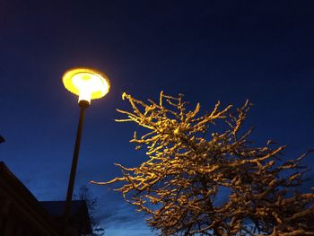 Low angle view of illuminated street light against sky