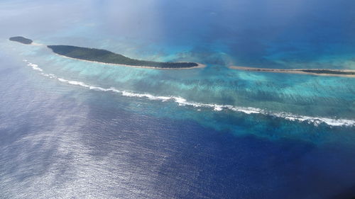 Aerial view of sea against blue sky