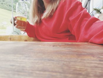 Midsection of woman sitting on table