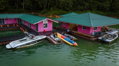 Boats moored in river by houses