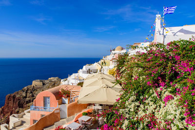 Scenic view of sea and buildings against blue sky