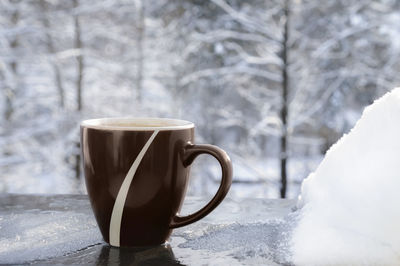 Close-up of coffee cup on table during winter