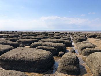 Rocks on beach against sky